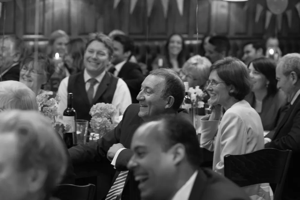 Smiling guests enjoying a dinner event, black and white.