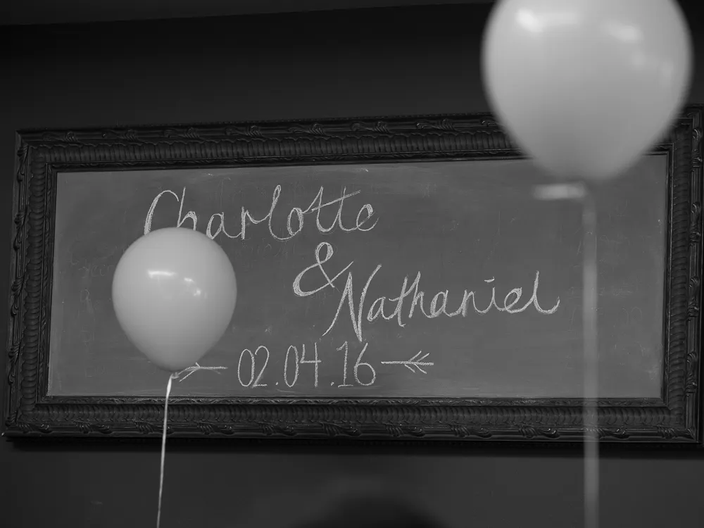 Black and white chalkboard with "Charlotte & Nathaniel 02.04.16" and balloons.