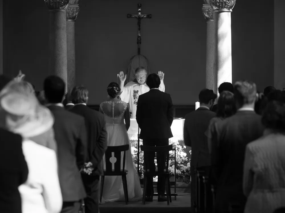 Priest conducting a wedding ceremony for a bride and groom in church.