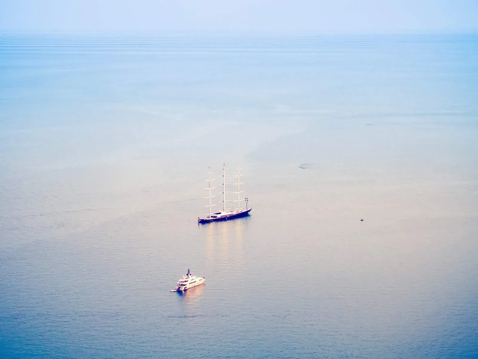 Aerial view of a lone boat on calm blue sea off the Sicilian coast.