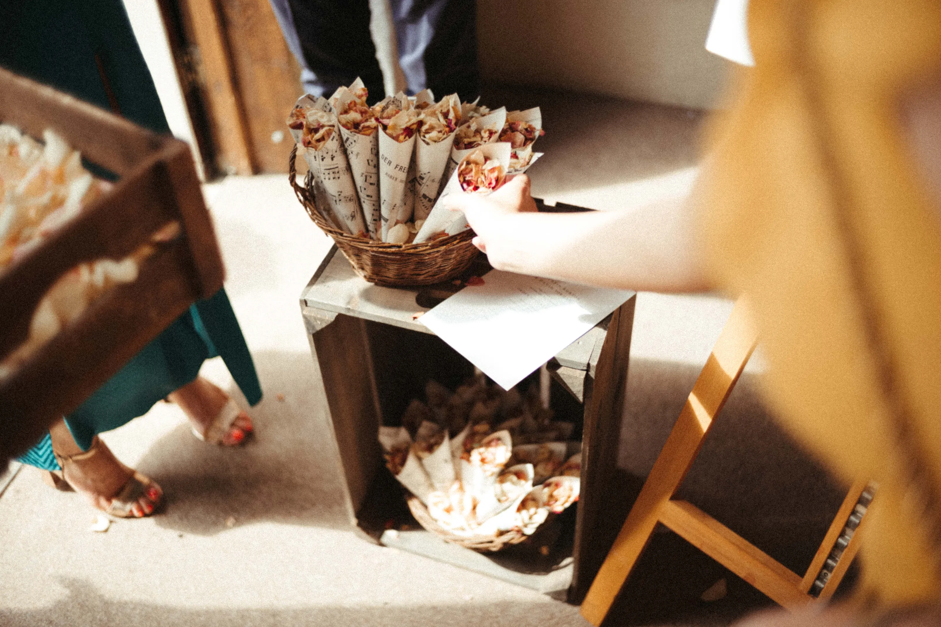 Hand reaching for musical note confetti cones from baskets on a crate.