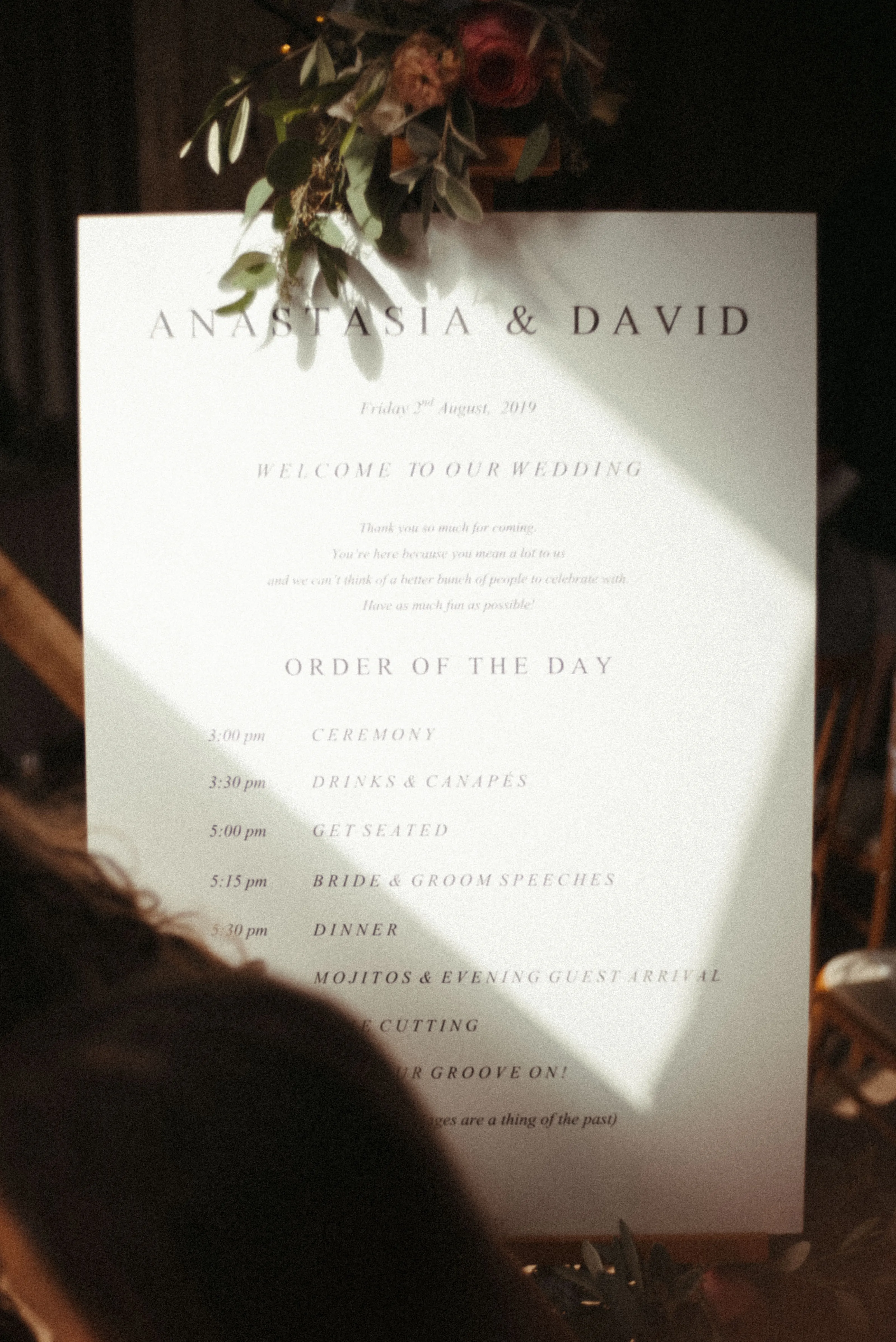 Wedding order of the day sign for Anastasia & David, with flowers.