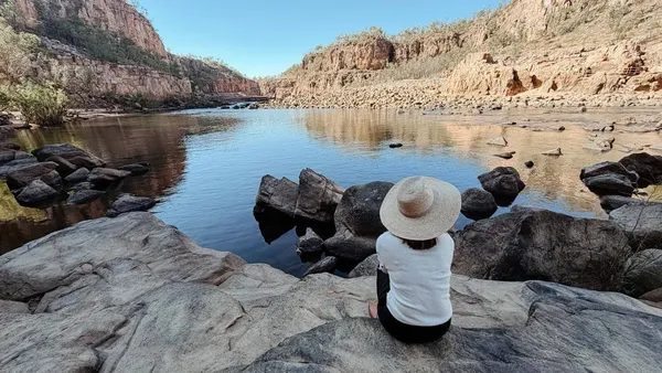A traveller seated above a rocky gorge pool in Nitmiluk National Park.