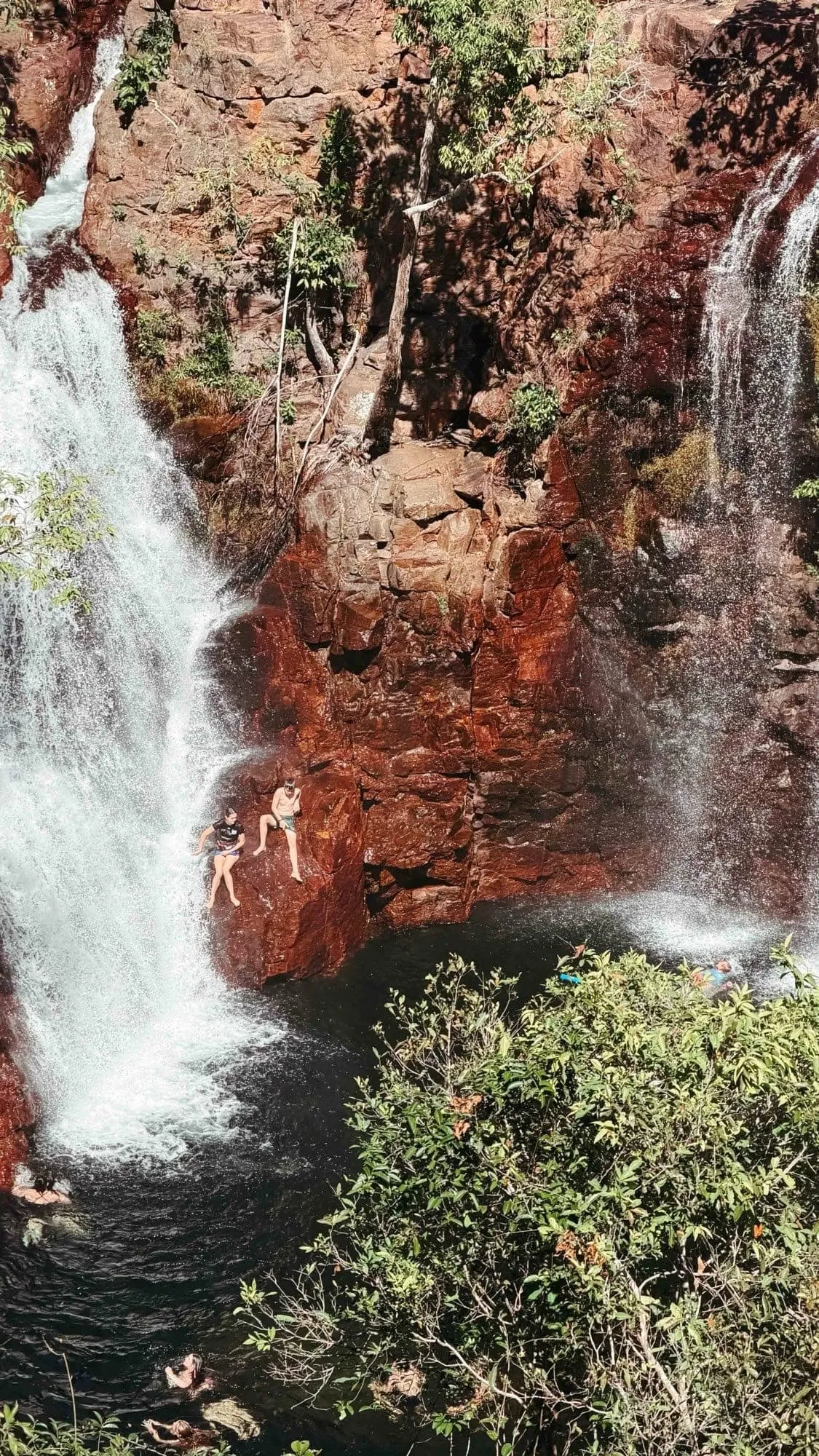 Swimmers beside the twin cascades of Florence Falls in Litchfield National Park.