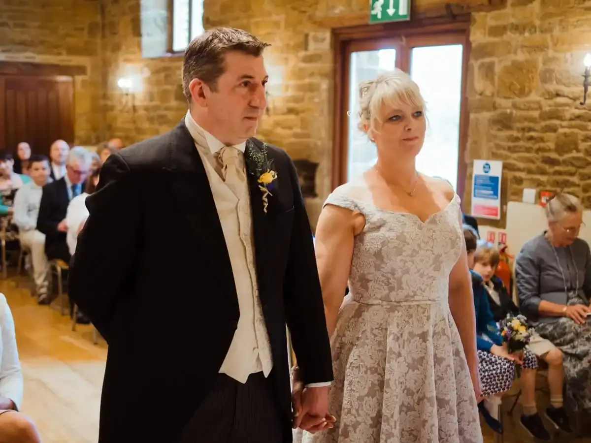 Bride and groom holding hands during their wedding ceremony.