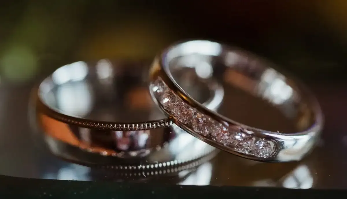 Two silver wedding bands, one plain, one set with diamonds.