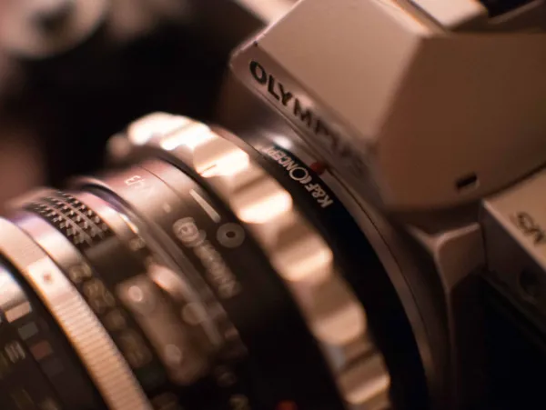 Close-up of the aperture ring on a legacy Nikon lens in warm light.