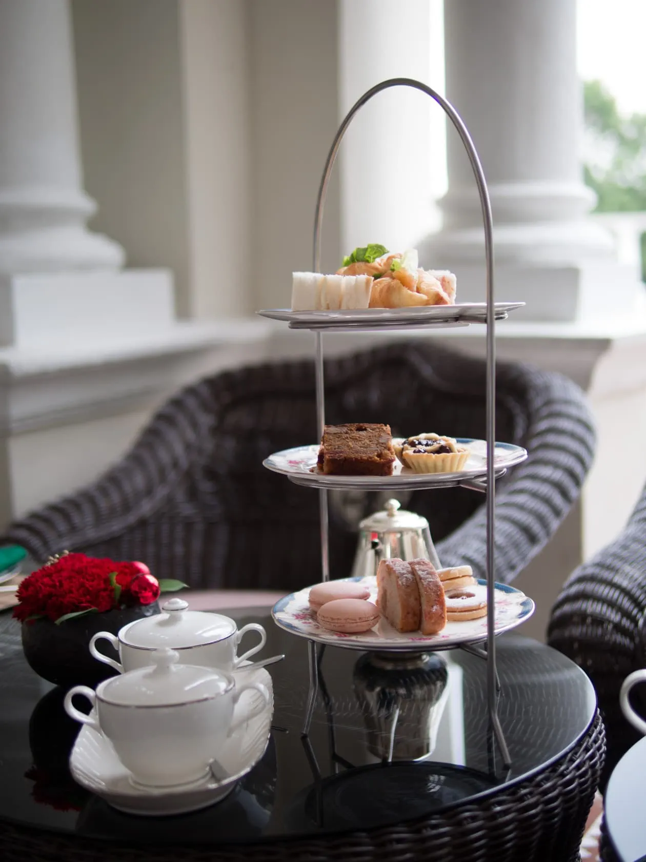 The full afternoon-tea stand on the veranda at Carcosa Seri Negara, silver teapot and floral china alongside