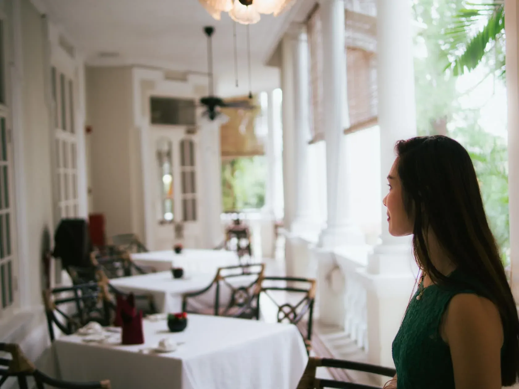 A woman looking out from a colonial tearoom window in Kuala Lumpur.