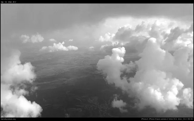 Billowing cumulus cloud seen from the aircraft window, black and white.