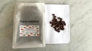 Smooth roasted Pantan CUACA coffee beans from Hana Roastery with info on flavor notes, packaged in a minimalist pouch, ideal for coffee enthusiasts and specialty coffee lovers.