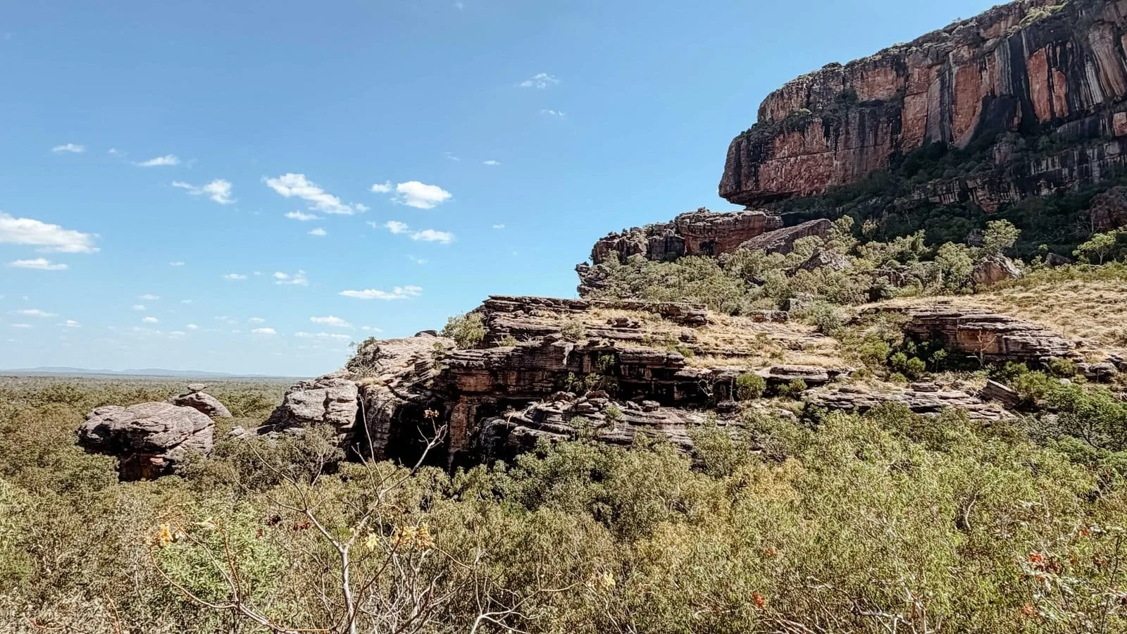 Layered sandstone escarpment beneath a clear blue sky in Kakadu National Park.