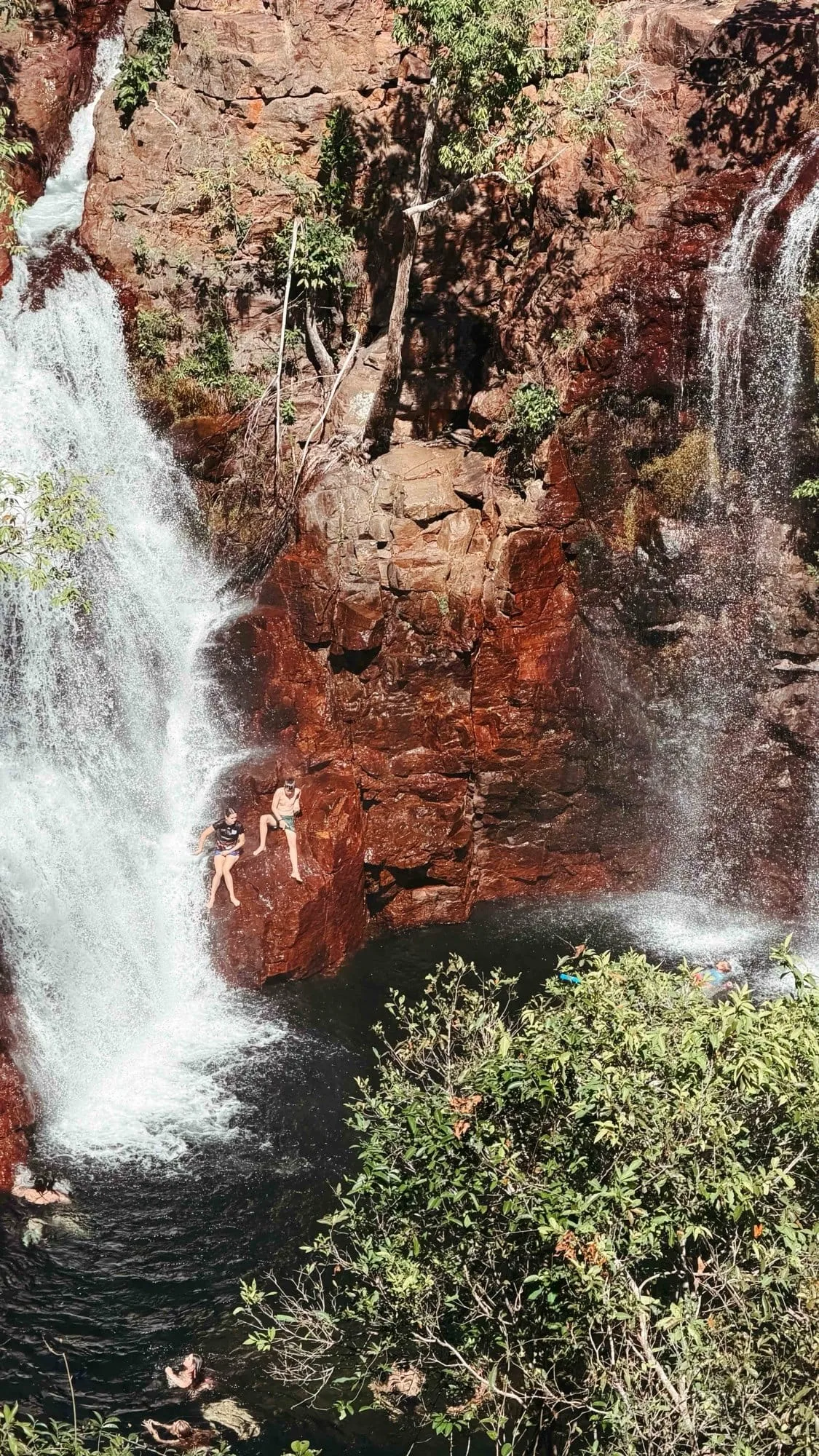 Swimmers beside the twin cascades of Florence Falls in Litchfield National Park.